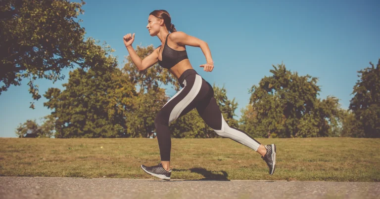 Mujer corriendo a paso ligero por un parque con luz natural