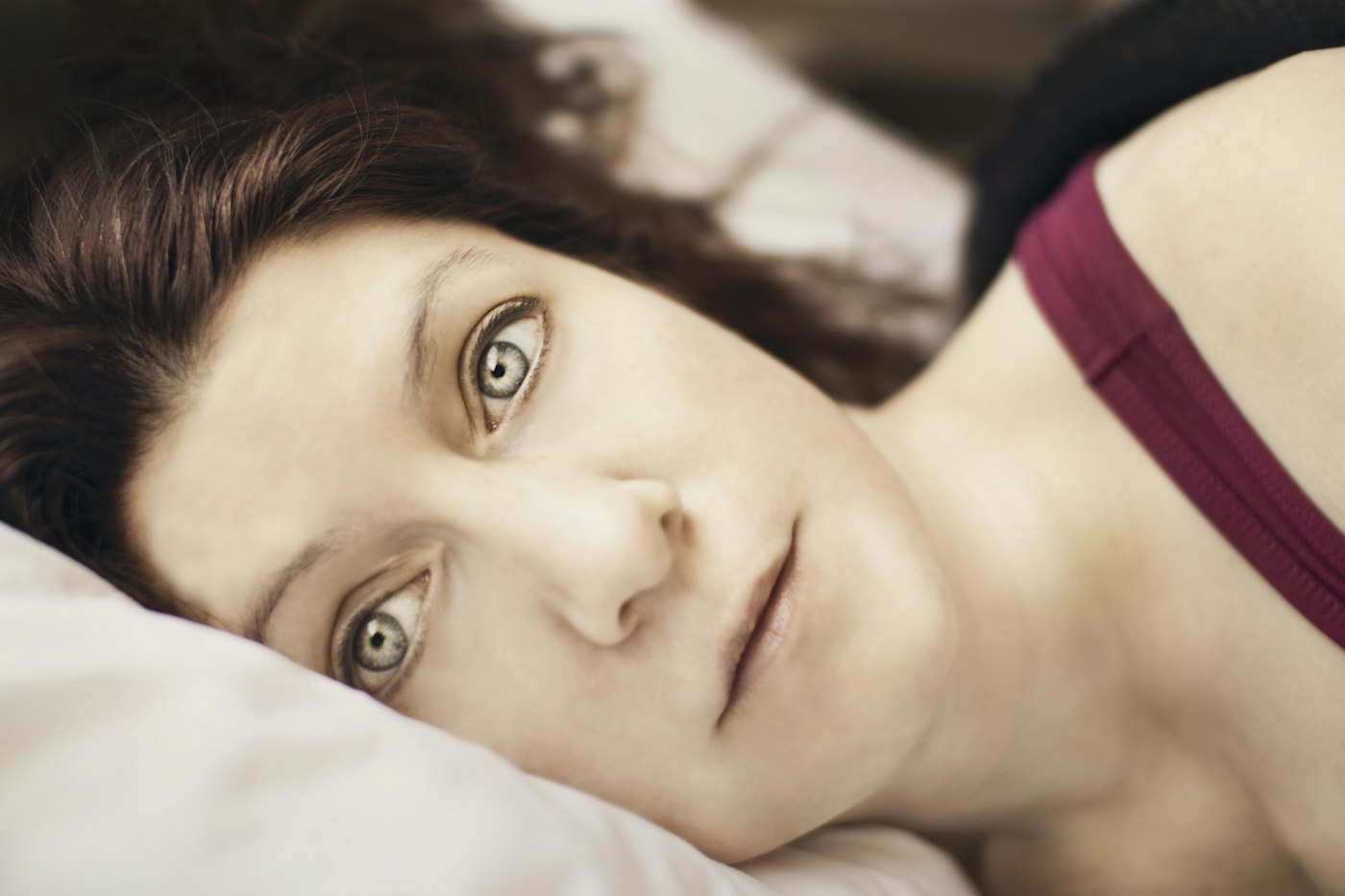 Mujer despierta de madrugada en la cama, sin poder volver a dormirse